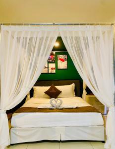 - une chambre avec un lit et des rideaux blancs dans l'établissement SaiGon Rose Hotel, à Hô-Chi-Minh-Ville