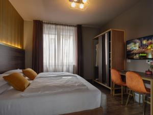 sypialnia z łóżkiem, biurkiem i telewizorem w obiekcie Hotel Giulietta w Weronie