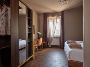 Hotel Giulietta في فيرونا: غرفة نوم مع مرآة وسرير ومكتب
