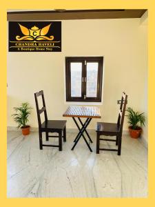 einen Tisch, 2 Stühle und einen Spiegel in einem Zimmer in der Unterkunft Chandra Haveli Boutique Homestay in Jaisalmer
