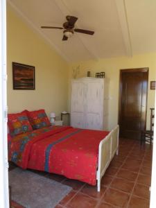 1 dormitorio con 1 cama y ventilador de techo en B&B Finca la Manchica, en Cartagena