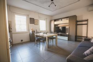 una cucina e un soggiorno con tavolo e sedie di Grey House Pavia a Pavia