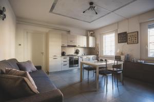 a living room with a couch and a table and a kitchen at Grey House Pavia in Pavia