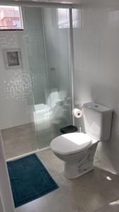 een witte badkamer met een toilet en een douche bij Pousada Carmel in Ametista do Sul