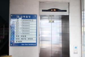 ein Schild an der Seite eines Gebäudes mit Aufzug in der Unterkunft Hostel Kpop in Seoul
