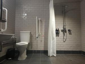 a bathroom with a shower and a toilet and a sink at BrewDog DogHouse Manchester in Manchester +17 photos