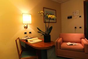 a room with a desk and a chair and a table with a lamp at Hotel Cristallo in Giulianova