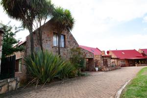 a brick building with palm trees next to a street at Critchley Common in Dullstroom