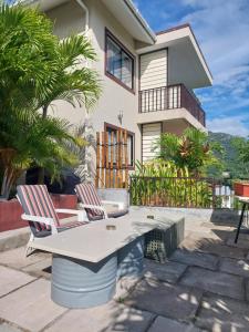 two chairs and a table in front of a house at La Vida Selfcatering Apartements in Mahe