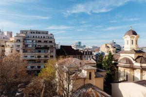 una vista di una città con edifici e una chiesa di Romanian Athenaeum 1BR Apartment with Amazing View a Bucarest