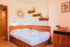 una camera da letto con un letto grande con lenzuola bianche di Romanian Athenaeum 1BR Apartment with Amazing View a Bucarest