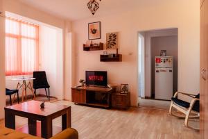un soggiorno con tavolo e frigorifero di Romanian Athenaeum 1BR Apartment with Amazing View a Bucarest