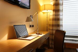 a laptop computer sitting on a desk with a lamp at Hotel Cristallo in Giulianova