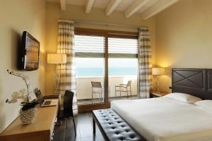 a bedroom with a bed and a desk and a window at Hotel Cristallo in Giulianova