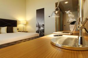 a bedroom with a bed and a desk with a laptop at Hotel Cristallo in Giulianova