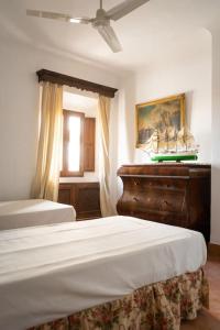 a bedroom with two beds and a dresser and a window at Cortijo El Solano in Antequera
