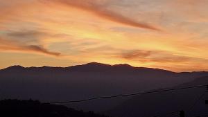 um pôr-do-sol sobre as montanhas com um arco-íris no céu em Kalimpong View Stay em Kalimpong