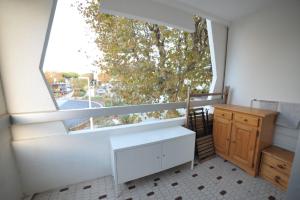 Zimmer mit einem großen Fenster, einem Schreibtisch und einem Tisch in der Unterkunft STUDIO SAINT CLAIR Vue Laterale MER in La Grande-Motte