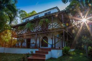 una casa en la jungla con el sol brillando en ella en Villa Maria Tayrona, Jungle and Sea Experience en Los Naranjos