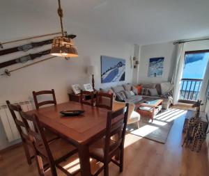 a dining room and living room with a table and chairs at Inmocyma Cerler-Prados de Velarta C2 8 -vistas panorámicas in Cerler
