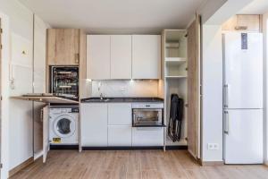 cocina con armarios blancos, lavadora y secadora en Global Home - PADA en Madrid