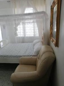 a bedroom with a couch and a bed with a window at Neighbourly Nest in Mombasa