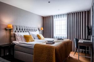 a hotel room with a large bed with yellow pillows at Best Western Hotell Hedåsen in Sandviken