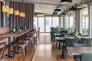 uma sala de jantar com mesas, cadeiras e lustres em Best Western Hotell Hedåsen em Sandviken