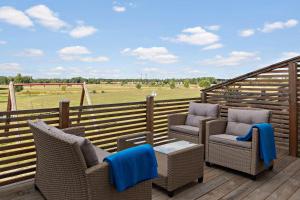 a deck with wicker chairs and a view of a field at Best Western Hotell Hedåsen in Sandviken