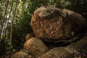 a large rock sitting in the middle of a forest at Villa Maria Tayrona, a Kali Hotels in Los Naranjos