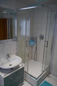 La salle de bains est pourvue d'une douche et d'un lavabo. dans l'établissement Hotel Auszeit im Euro Rastpark Guxhagen, à Guxhagen