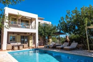 a villa with a swimming pool and patio furniture at Astra Villas in Skala