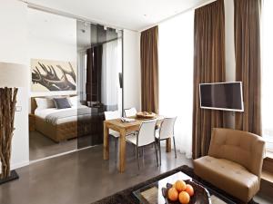 a living room with a table and a bedroom at VISIONAPARTMENTS Otto-Braun-Strasse - contactless check-in in Berlin