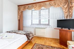 a bedroom with two beds and a flat screen tv at DW Paweł in Zakopane