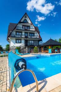 a resort with a swimming pool in front of a building at DW Paweł in Zakopane