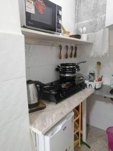 a kitchen with a stove and a microwave at Neighbourly Nest in Mombasa