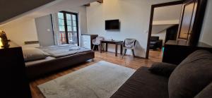 a living room with a couch and a table with a desk at Apartman Deluxe villa Barbora Hrabovo in Ružomberok