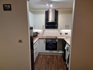 a kitchen with white cabinets and a stove top oven at Washingtons Emerald 2 bed executive Apartment in Washington