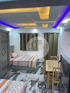 Habitación con 2 camas, mesa y sillas en ستوديو المعموره Jerma apartments en Alexandria