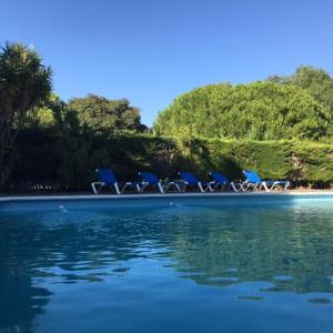 a group of chairs sitting on a beach next to the water at Villa Torrealta, 4000 m2, estancia mínima en verano 7 días de sábado a sábado in Cádiz