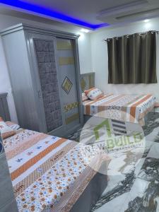 Un dormitorio con 2 camas y una puerta. en ستوديو المعموره Jerma apartments en Alexandria