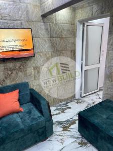 a living room with a blue couch and a door at ستوديو المعموره Jerma apartments in Alexandria