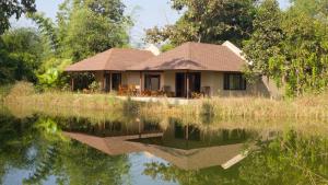 a house next to a body of water at Bagh Villas I Kanha in Kānha