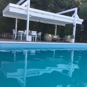 un patio con mesa y sillas y una piscina en Villa Torrealta, 4000 m2, estancia mínima en verano 7 días de sábado a sábado, en Cádiz