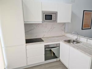a white kitchen with a sink and a microwave at DS Precioso LOFT a estrenar in Córdoba