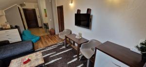 a living room with a tv and a table and chairs at Apartman Deluxe villa Barbora Hrabovo in Ružomberok