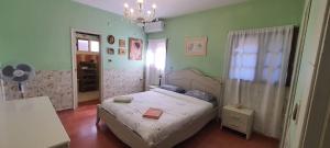 een kleine slaapkamer met een bed en een kroonluchter bij Desert Bird Guest House in Arad