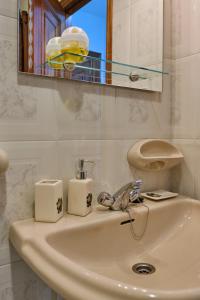 a sink in a bathroom with a mirror and a mirror at Apartamento en el centro de Portosin in Goyanes