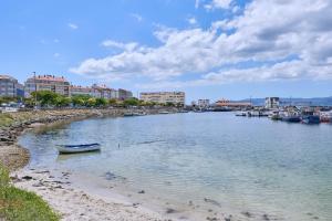 a river with a small boat on the shore at Apartamento en el centro de Portosin in Goyanes