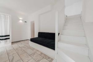 a staircase in a white room with a black couch at Mr & Mrs White Mykonos in Platis Gialos